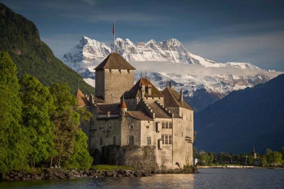 Chillon Castle on Lake Geneva with Alps route backdrop. Photo copyright Derry Brabbs. Used with permission.