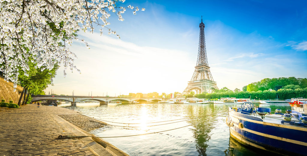 Paris Eiffel Tower reflecting in river Seine water at sunrise in Paris, France. Eiffel Tower is one of the most iconic landmarks of Paris at spring,