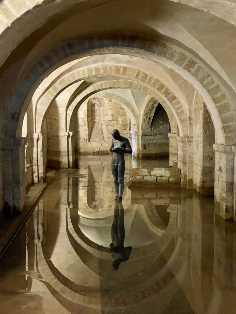 Winchester Cathedral flooded crypt with Antony Gormley statue Photo by JFPenn