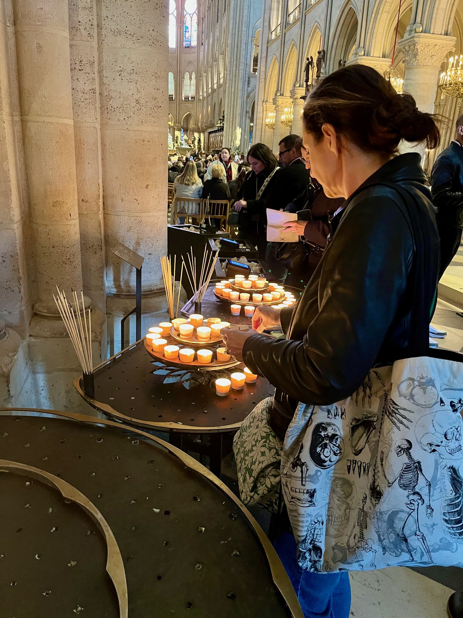 Jo Frances Penn lighting a candle, Notre-Dame de Paris. Photo by JFPenn