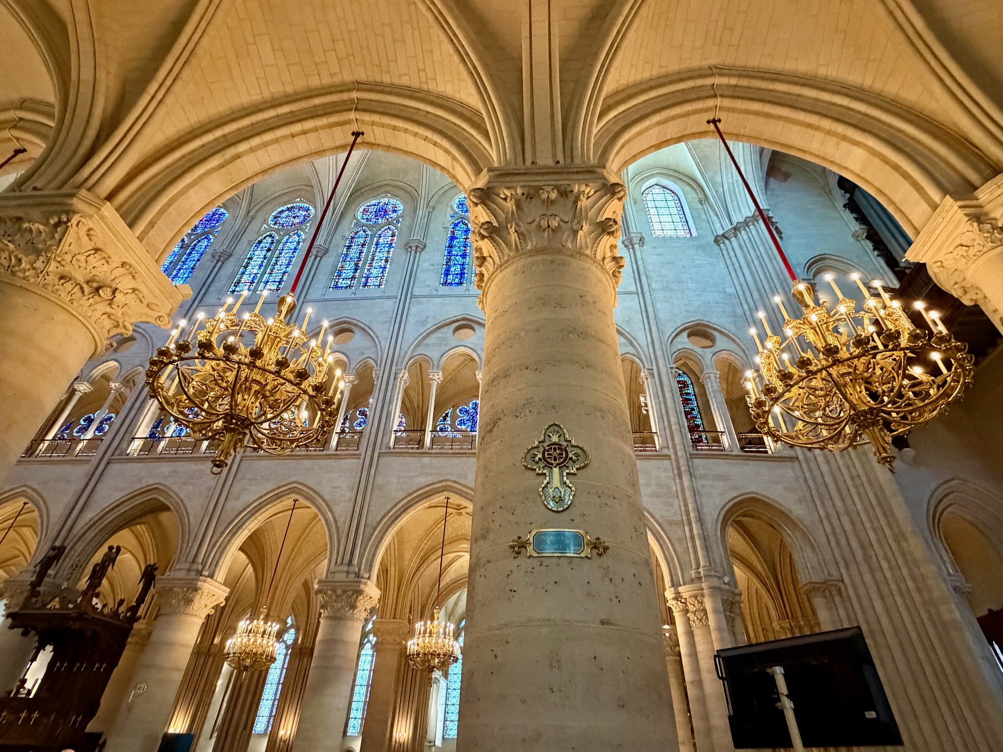Chandeliers and a Station of the Cross in the nave, Notre-Dame de Paris. Photo by JFPenn