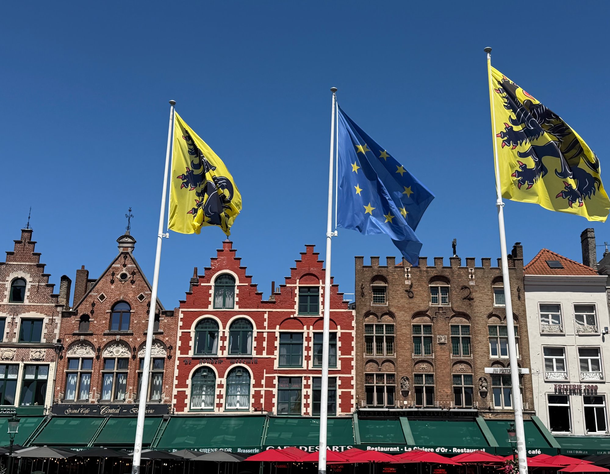 Flags of Flanders over the guild houses on the Markt, Bruges. Photo by JFPenn