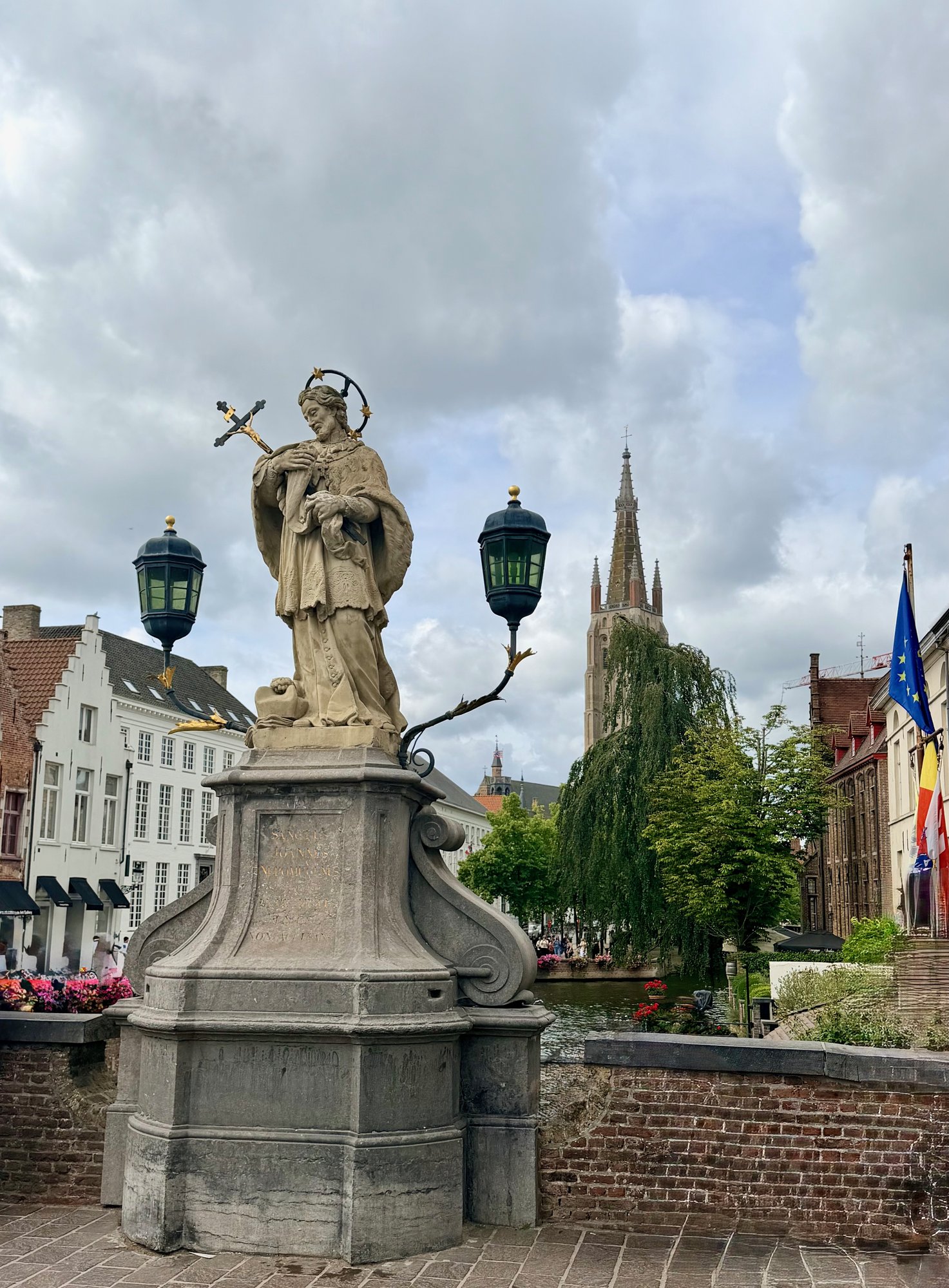 St John of Nepomuk on the bridge with the Church of Our Lady behind, Bruges. Photo by JFPenn